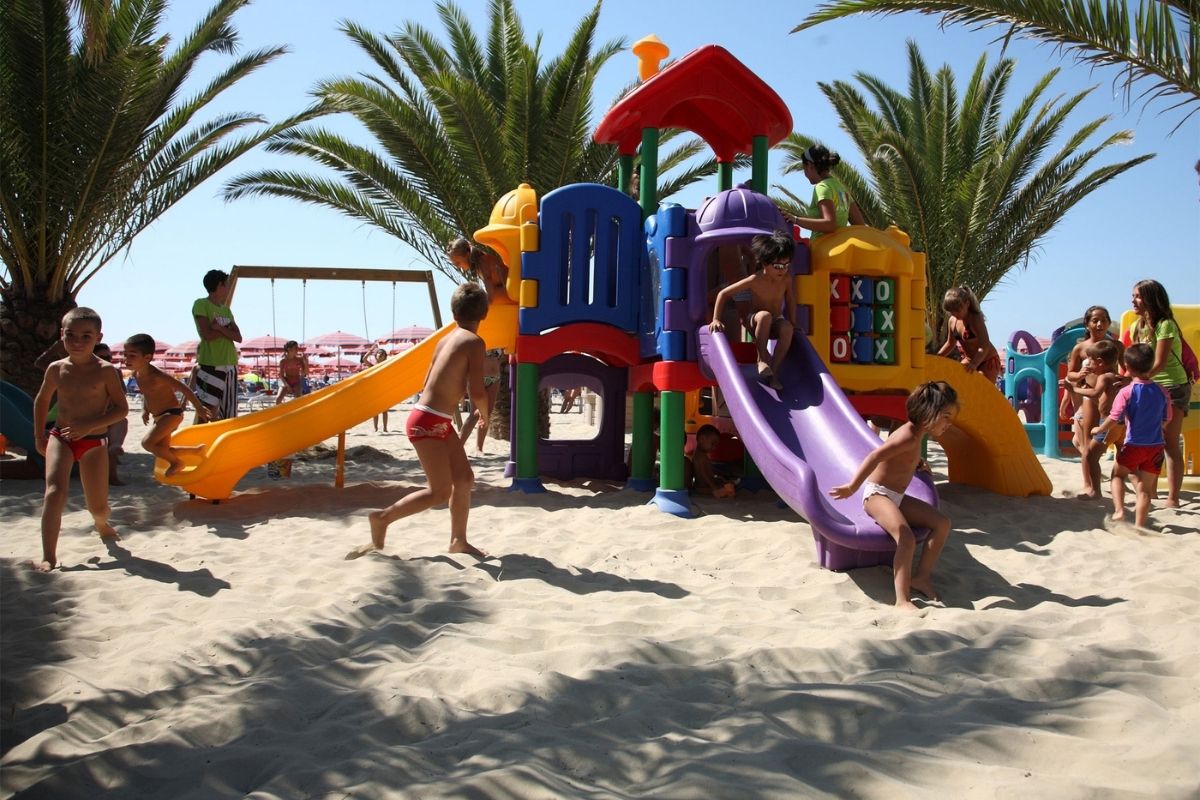 Vista della spiaggia di Giulianova con famiglie che giocano sulla sabbia, perfetta per bambini