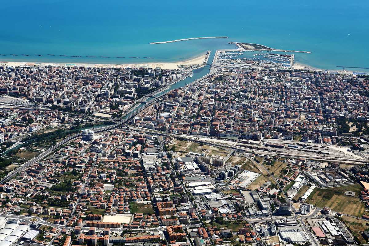 Persone che si divertono in spiaggia a Pescara, evidenziando il lungomare e attività acquatiche